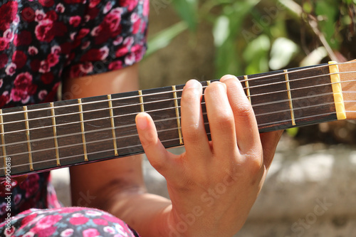 Young girl with a dress playing guitar