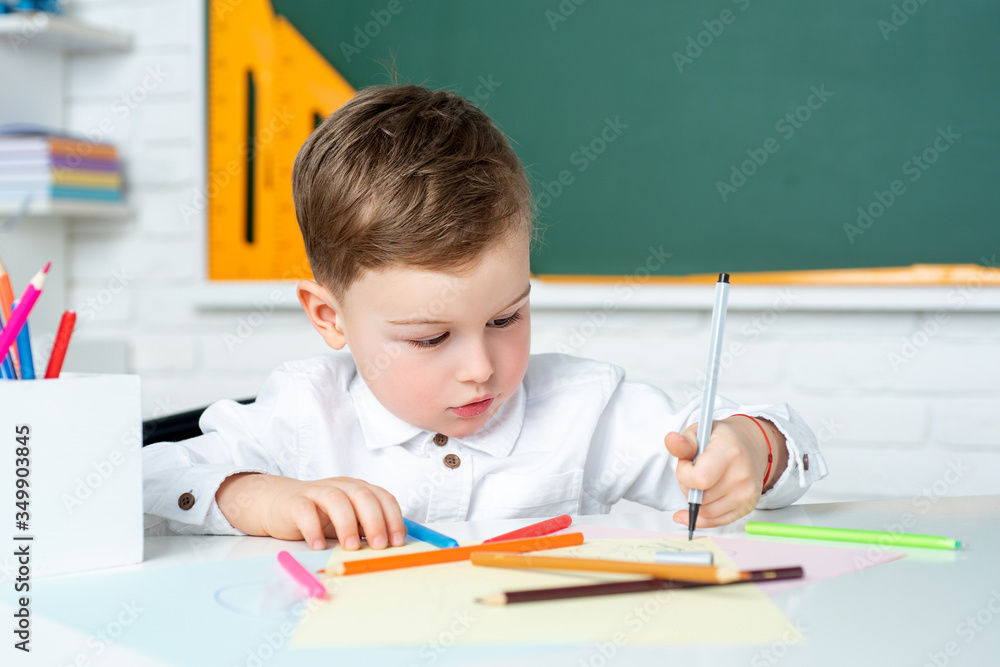 Cute child boy in classroom near blackboard desk. Kid is learning in class. Preschool education. Cute child boy in classroom near blackboard desk. Kid is learning in class. Preschool education.