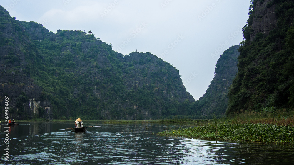 Vietnamese Boat owner rowing her Boat with legs at Ninh Binh, Vietnam, Asia
