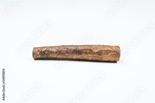 Thin cigar from twisted sheets on white background.