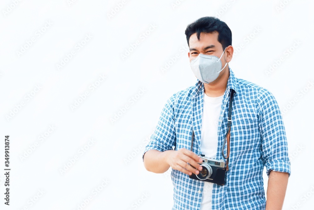 A young Asian man standing over white background wearing a medical face mask for protects against the spread of coronavirus.
A young Asian man standing over white background wearing a medical face mask for protects against the spread of coronavirus.