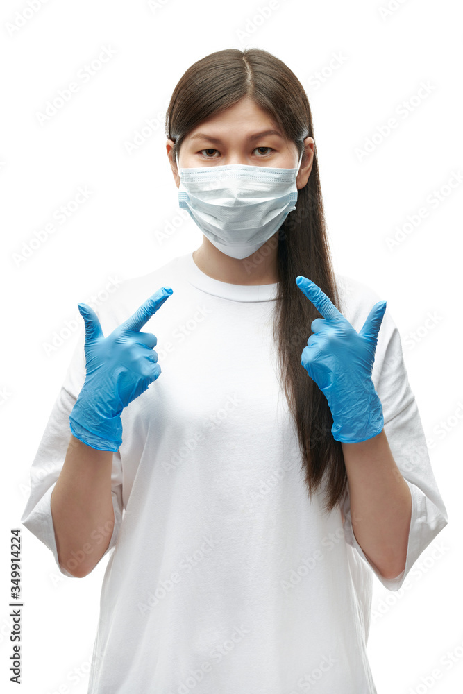 Young asian girl in medical mask and blue gloves pointing on protection on white background isolated