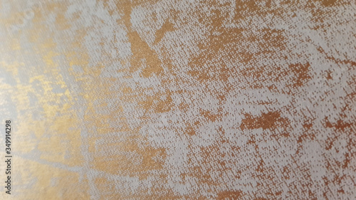 Sunflare at shabby pattern of textured wall surface with golden paint and grey scratches