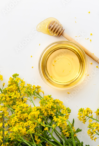 A bowl of honey with surepka flowers on a white background photo