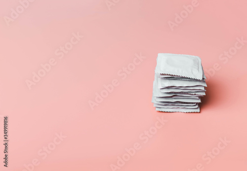 Condom on a pink background. The concept of safe sex, stopping the transmission of sexually transmitted diseases, STDs, AIDS