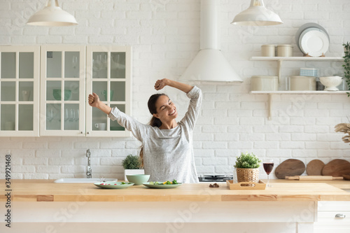 Obraz na plátně Happy millennial girl preparing healthy breakfast having fun in bright modern ki