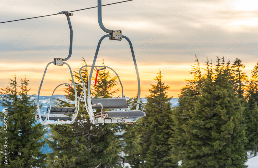 ski lift with seats going over the snow mountain in ski resort. ski lift with seats going over the snow mountain in ski resort.