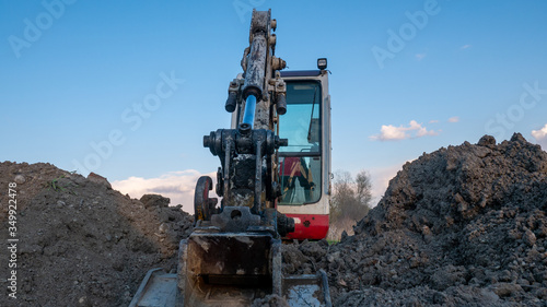 Crawler excavator front view digging on demolition site.