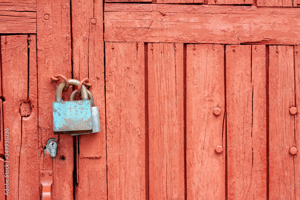 Big iron lock with peeling paint on teh old red wooden door can be used as background or texture Big iron lock with peeling paint on teh old red wooden door can be used as background or texture