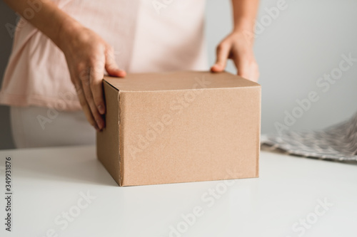 Woman holding a cardboard box, the parcel in hands. Delivery concept, mock up.