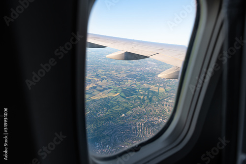 Aerial high angle above view from airplane plane over suburbs outskirts of London in United Kingdom with houses farm fields