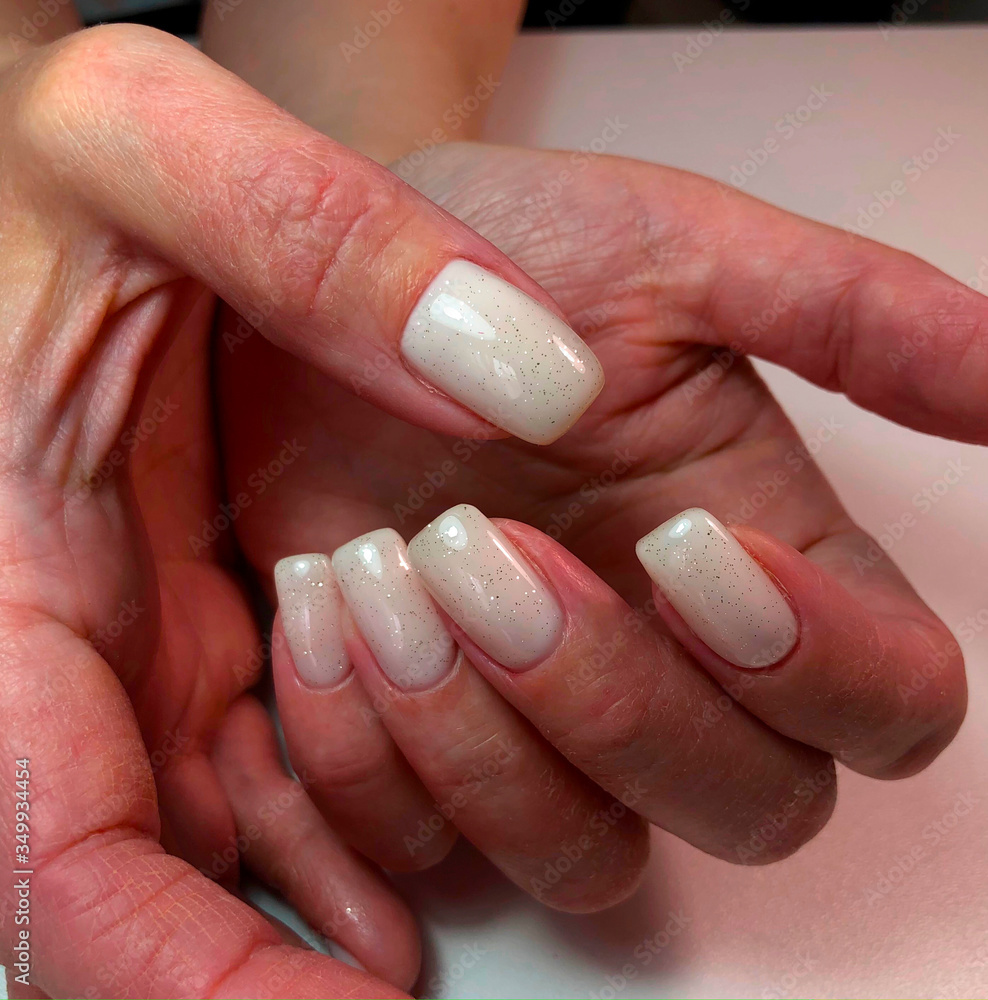 A woman's hand with a white manicureon nails A woman's hand with a white manicureon nails