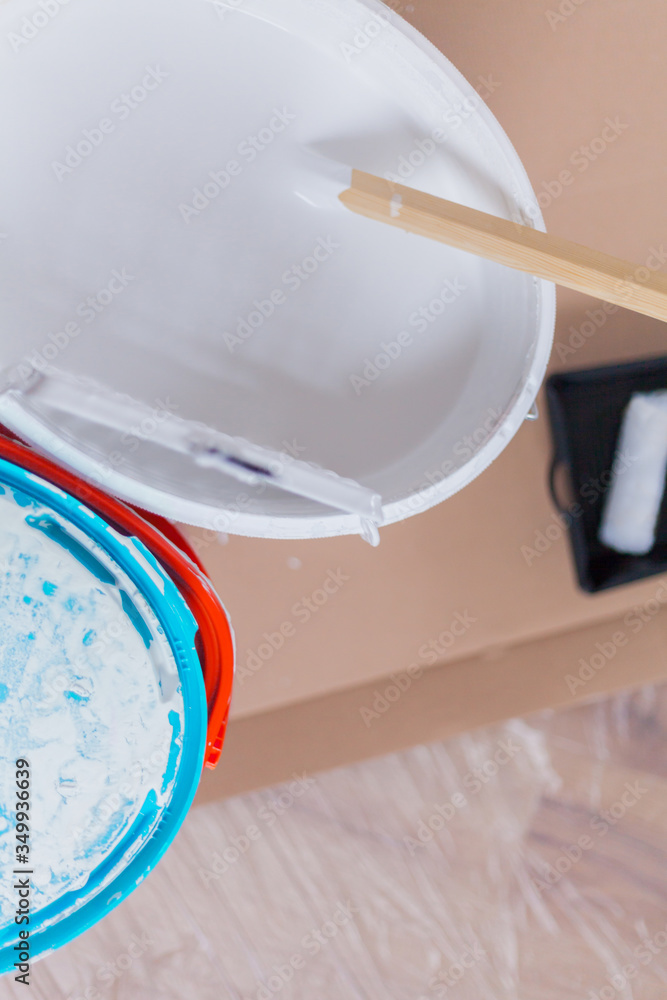 Paint bucket with white wall paint and with wooden stirring rod and
