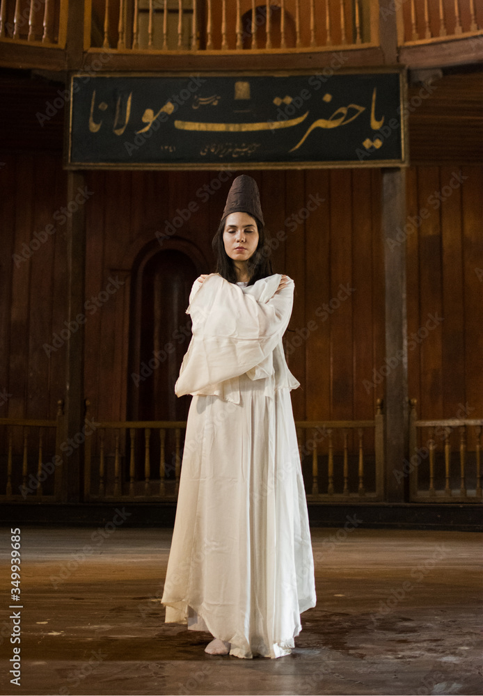 Fototapeta premium Portrait for a Sufi whirling woman dancer wearing white dress (Turkish/Semazen) performing art of Sama or physically active meditation of Sufism, and during spiritual dancing performance at Egypt