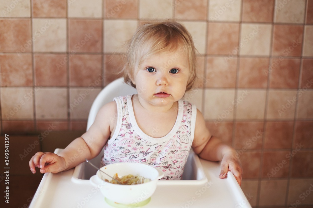Little girl eats lunch at the white kids table Little girl eats lunch at the white kids table