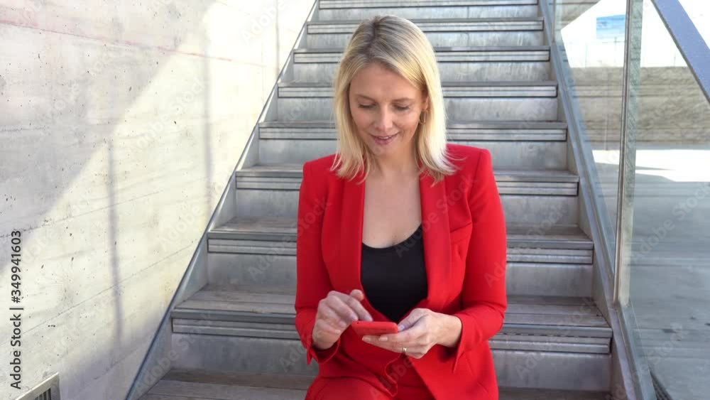 Middle-aged Businesswoman using smartphone outdoors. Middle-aged Businesswoman using smartphone outdoors.