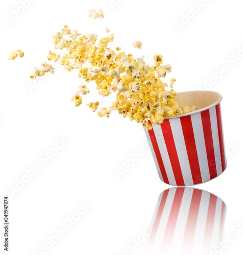 Flying popcorn from paper striped bucket isolated on white background