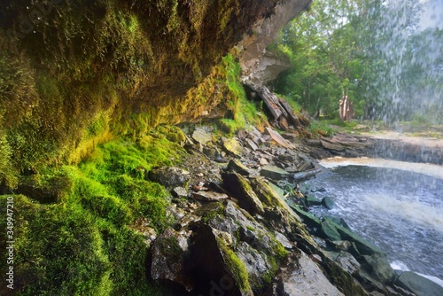 A view of the Jagala joa waterfall in a green summer forest. Cliff, mossy stones and water splashes close-up. idyllic landscape. Environmental conservation, recreation, sightseeing theme. Estonia photo