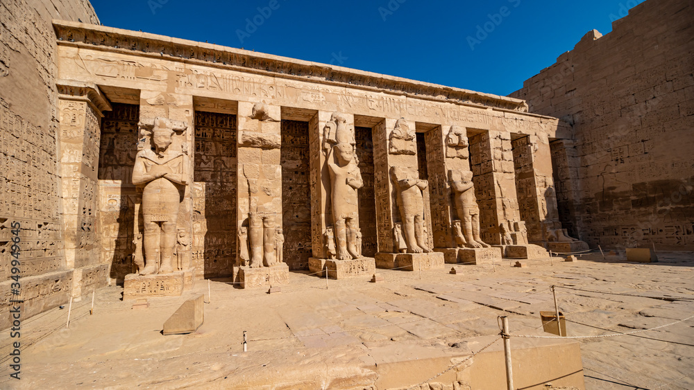 Obraz premium Temple of Medinet Habu. Egypt, Luxor. The Mortuary Temple of Ramesses III at Medinet Habu is an important New Kingdom period structure in the West Bank of Luxor in Egypt.