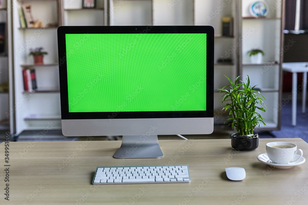 Computer desktop with mock-up green screen white background in office and Lovely plant in black pot Computer desktop with mock-up green screen white background in office and Lovely plant in black pot