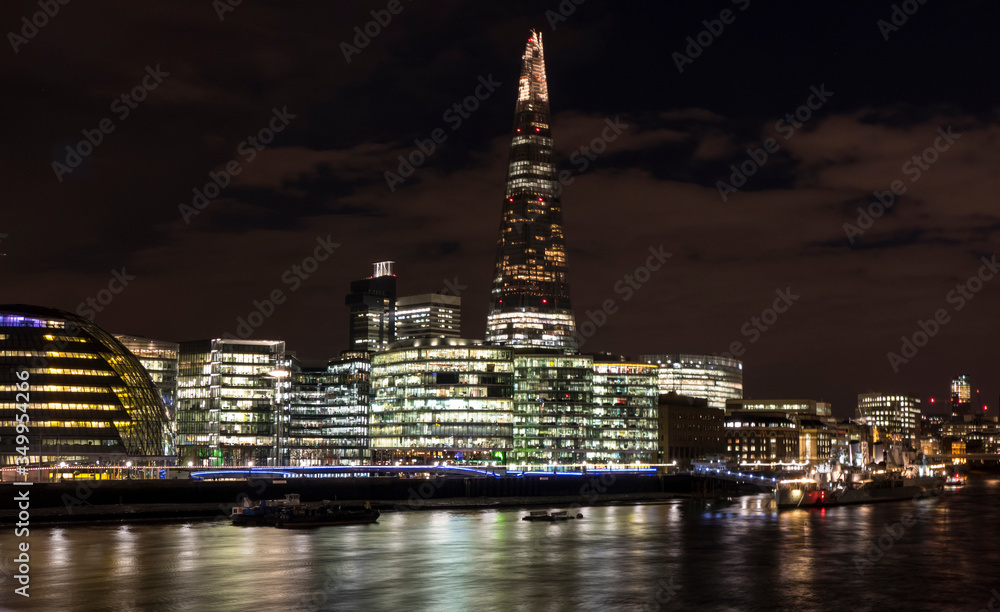 Skyline of London at night with skyscrapers illuminated in background