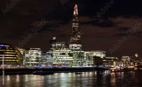 Skyline of London at night with skyscrapers illuminated in background
