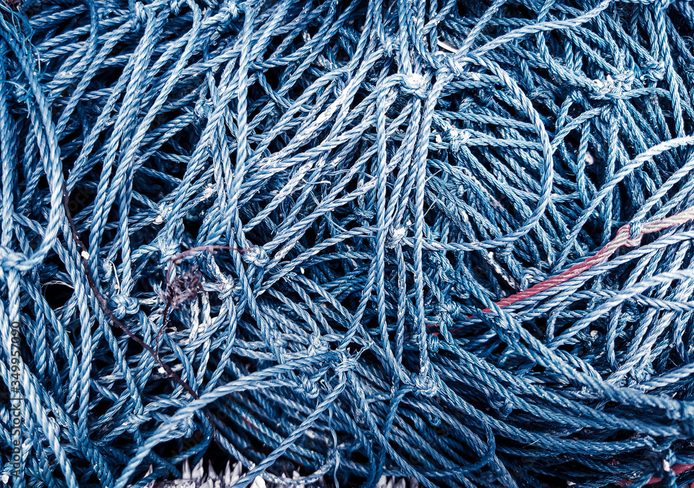 Navy-blue fishnets of rope knots and blue maritime background. Navy-blue fishnets of rope knots and blue maritime background.