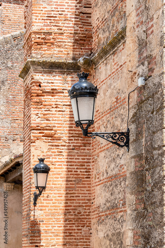 Old style lamps hanging outside of a brown bricks wall