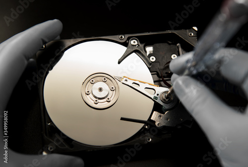 Φωτογραφία the disassembled hard disk is repaired using tools and rubber gloves to ensure c