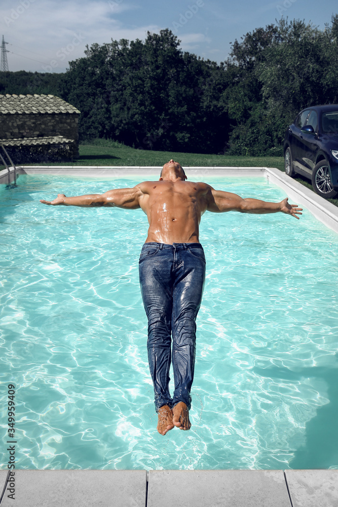detektor klon kapacitet Muscular young sexy wet naked guy falls into the pool in blue jeans  outdoors. Athletic tanned man resting on vacation. Stock Photo | Adobe Stock