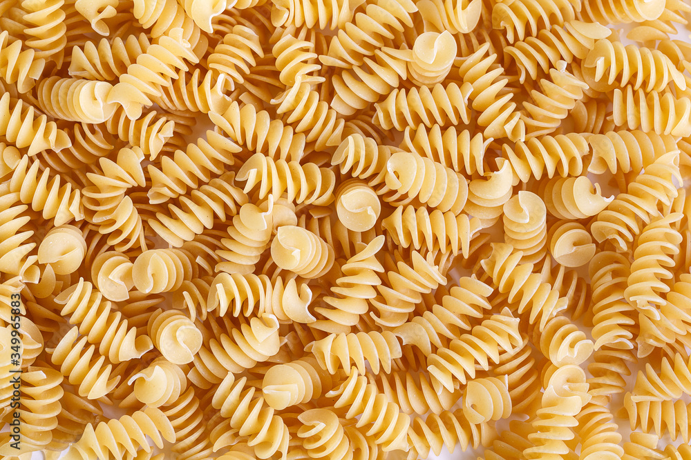 Dried corkscrew shaped pasta or eliche pasta over white background. Close-up Dried corkscrew shaped pasta or eliche pasta over white background. Close-up