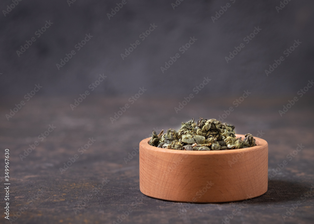  Green tea dry in wooden cup on m with a close-up copy of the space. Healthy organic vitamin herbal tea. - obrazy, fototapety, plakaty 