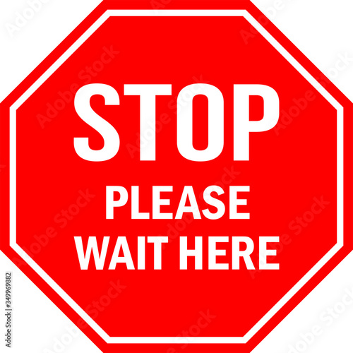 STOP Please wait here sign. Red octagonal background. Social distancing floor sign tells visitors or workers to wait. photo