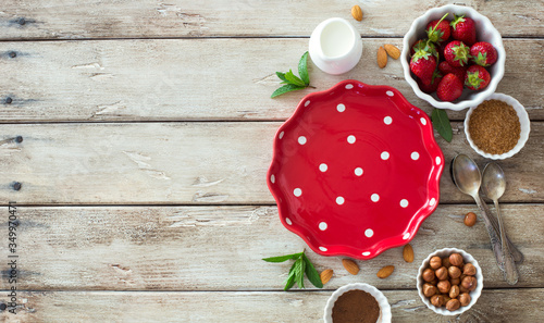 Food wooden background with empty cooking tray, strawberries and baking ingredients