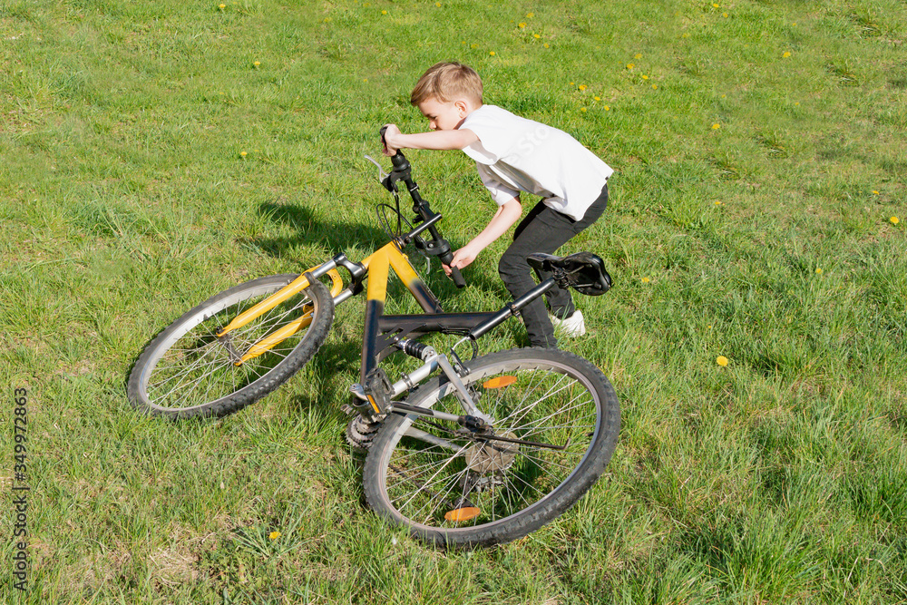 A small boy tries to lift a Bicycle A small boy tries to lift a Bicycle