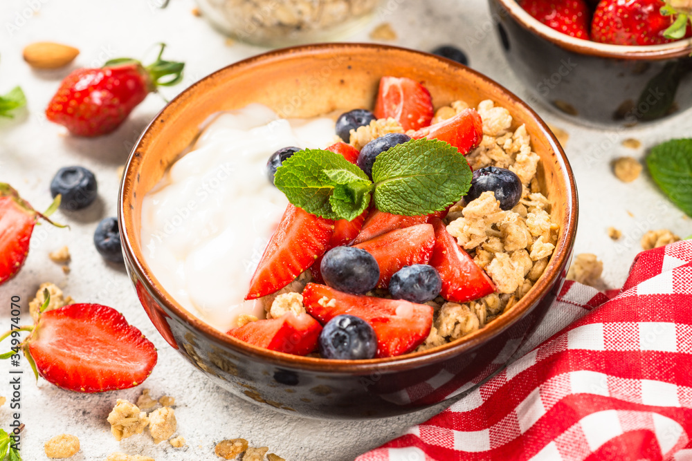 Greek yogurt granola with fresh berries on white stone table. Greek yogurt granola with fresh berries on white stone table.