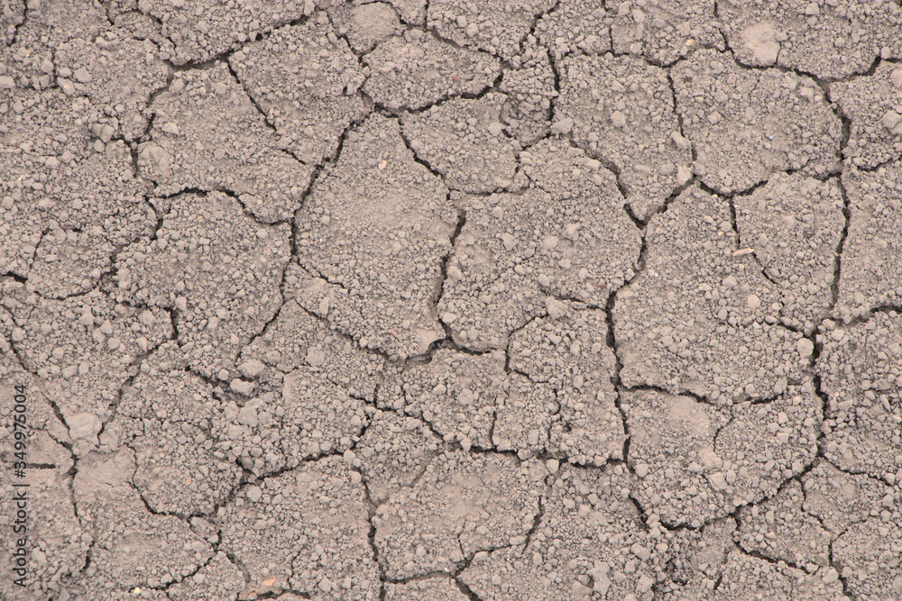 Cracked earth from drought. Dry season, no harvest. Textured cracks on chernozem, background. Cracked earth from drought. Dry season, no harvest. Textured cracks on chernozem, background.