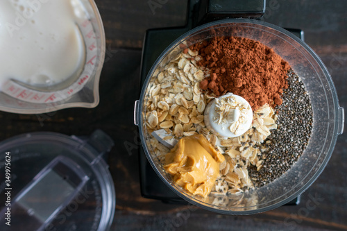 Chocolate Overnight Oatmeal Smoothie Ingredients: Rolled oats, chia seeds, and other breakfast smoothie ingredients in a food processor bowl photo