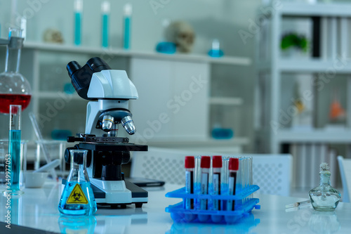 blood sample in test tube glassware and microscope in science laboratory equipment to diagnosis for virus pandemic
