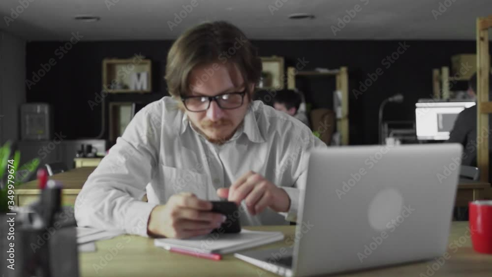 Young businessman is working on smartphone at the office Young businessman is working on smartphone at the office