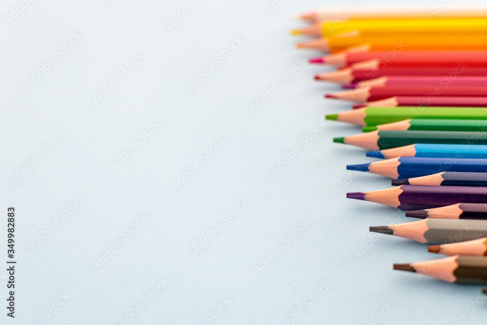 a set of colourful pencils lined up from dark to light focusing on the foreground a set of colourful pencils lined up from dark to light focusing on the foreground
