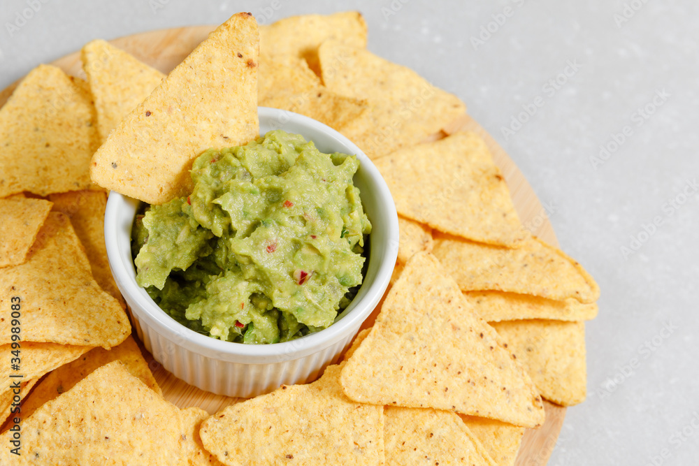 Guacamole sauce with nachos on white background Guacamole sauce with nachos on white background