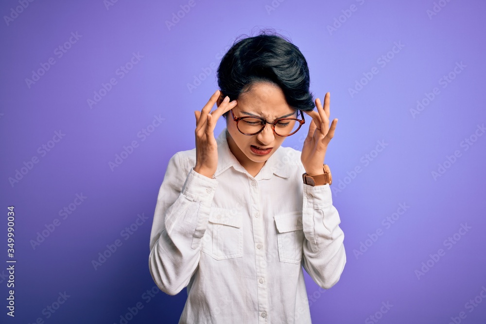 Young beautiful asian girl wearing casual shirt and glasses standing over purple background with hand on headache because stress. Suffering migraine. Young beautiful asian girl wearing casual shirt and glasses standing over purple background with hand on headache because stress. Suffering migraine.