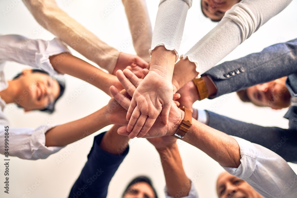 Group of business workers standing with hands together at the office Group of business workers standing with hands together at the office