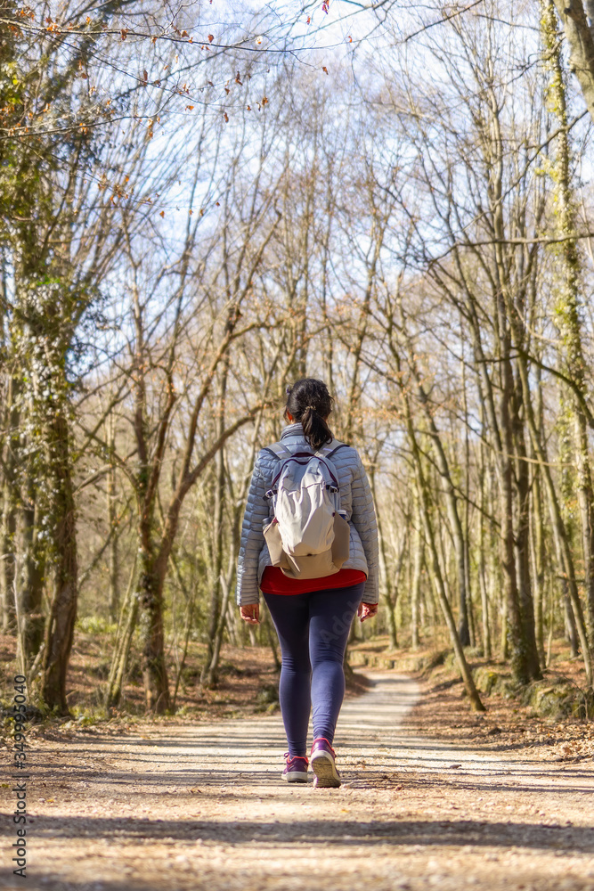 Sporty Spanish woman walking on the pathway in the forest in springtime, Garrotxa Volcanic Zone Natural Park Sporty Spanish woman walking on the pathway in the forest in springtime, Garrotxa Volcanic Zone Natural Park