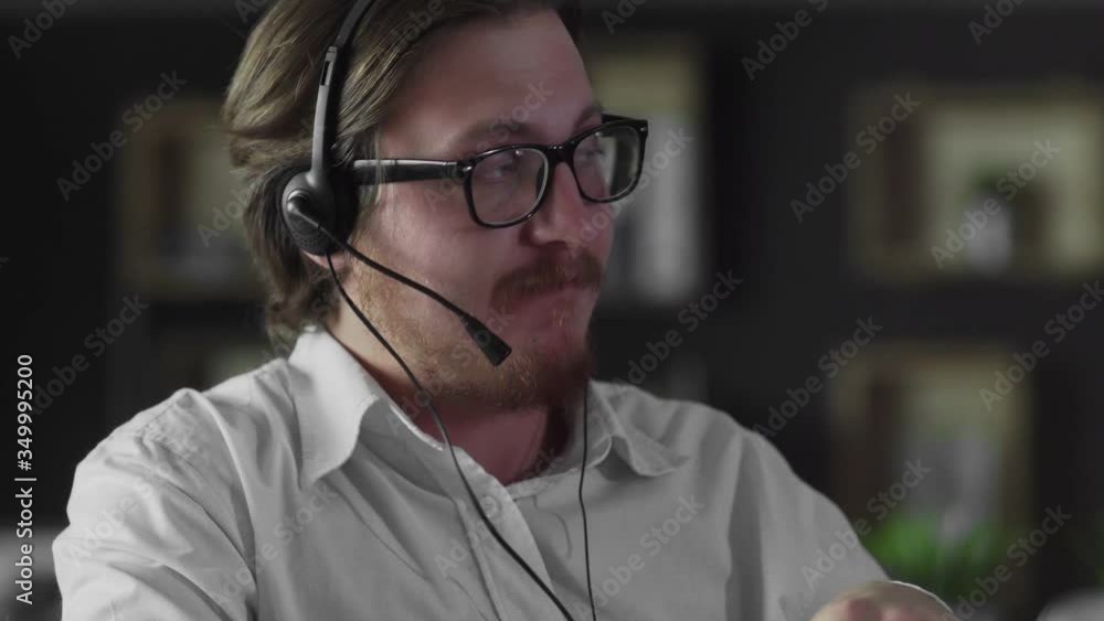 Young manager in headphones is working in office Young manager in headphones is working in office