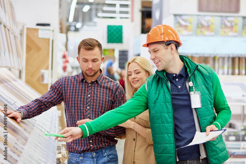 beautiful couple customers asked for help and advice from warehouse worker in market, worker in uniform is credible beautiful couple customers asked for help and advice from warehouse worker in market, worker in uniform is credible