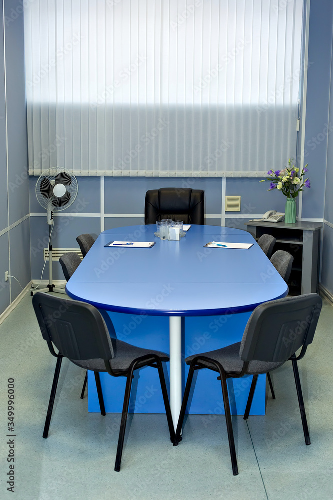 Fototapeta premium Blue table for negotiations, meetings, Executive chair, fan, office. Rent.