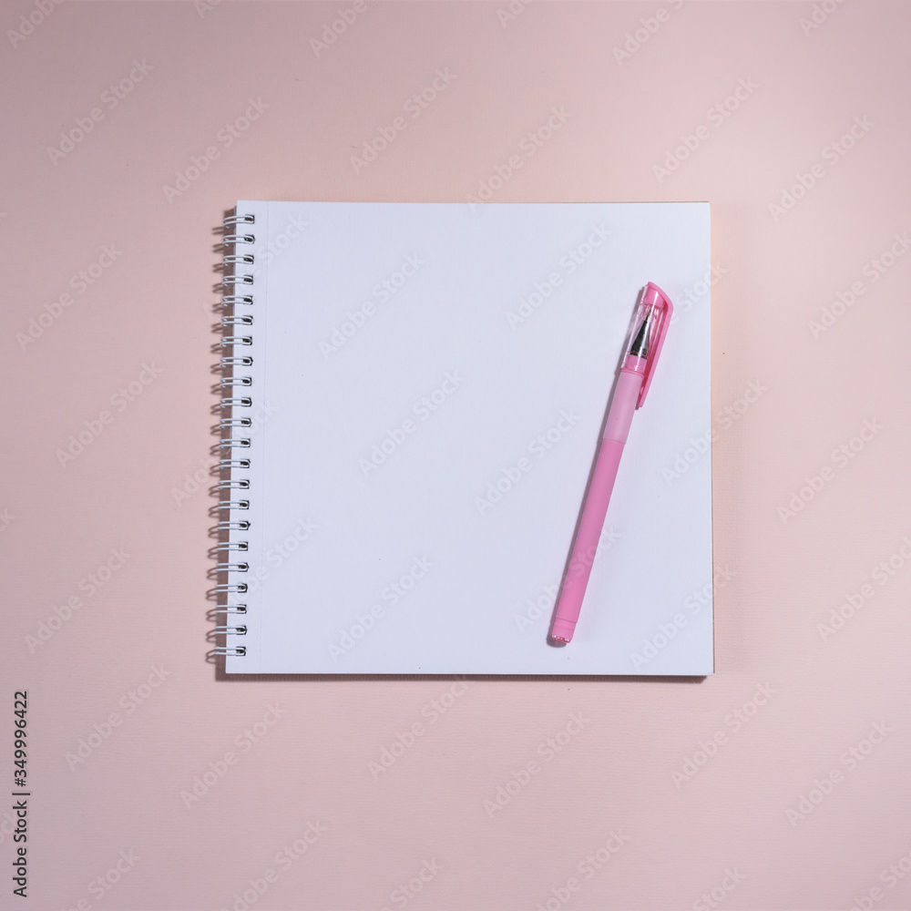 Opened book and pen on it on the pink background. Opened book and pen on it on the pink background.