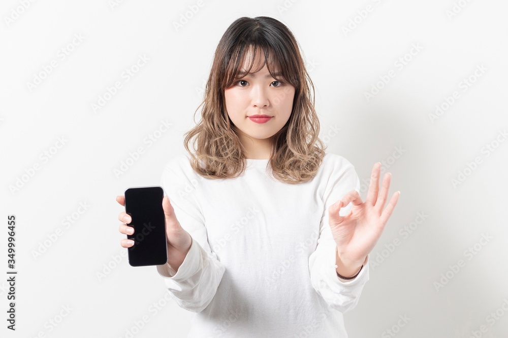 Fototapeta premium スマホを持つ若い女性